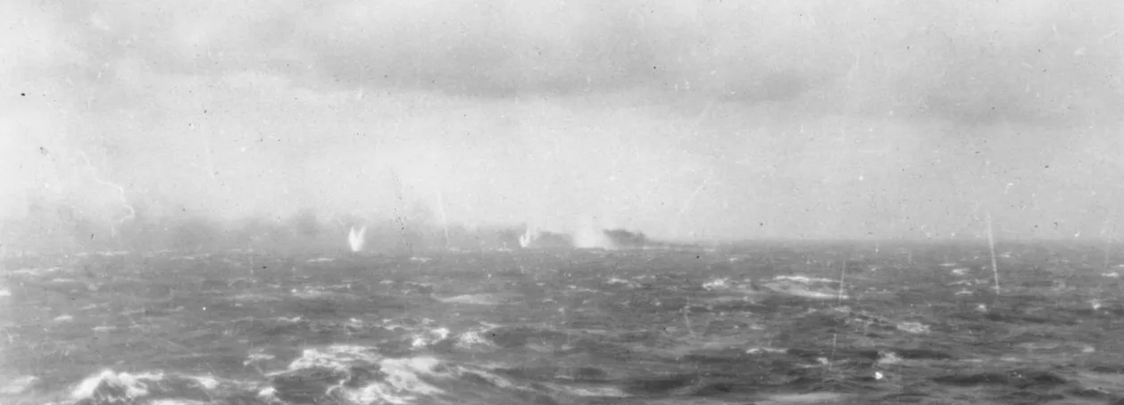 The German battleship Bismarck under heavy fire and burning on the horizon during its final engagement