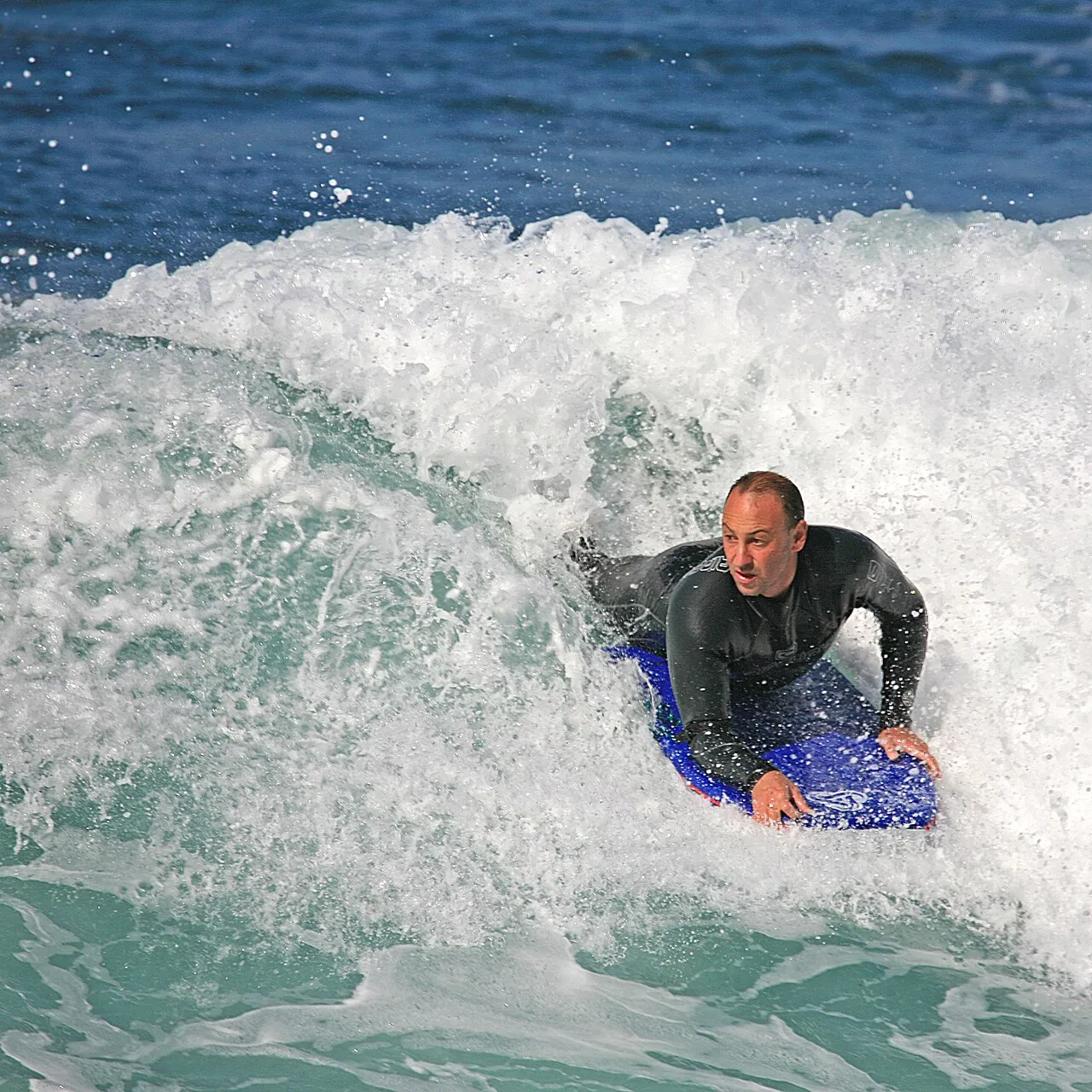 Bodyboarder riding a powerful wave during a professional competition