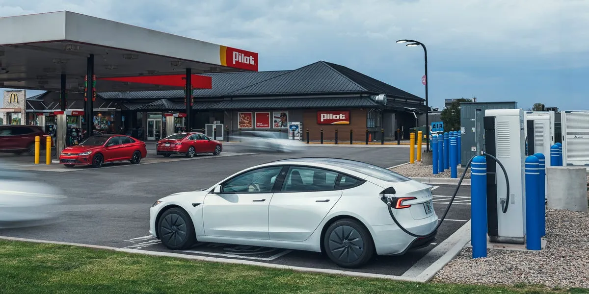 Electric vehicle, hybrid, and gas car parked together during a comparative efficiency test
