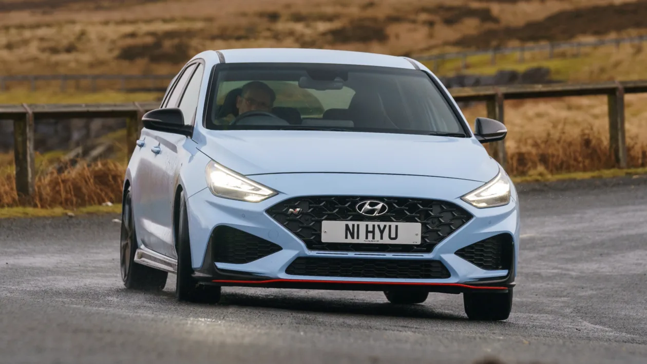 Hyundai i30 N performance hot hatch driving on winding asphalt road