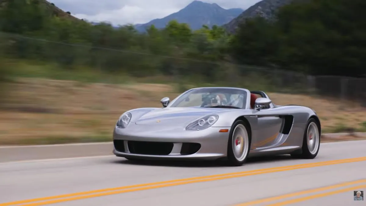 Jay Leno hands his Porsche Carrera GT keys to watch executive Wilhelm Schmid for a test drive