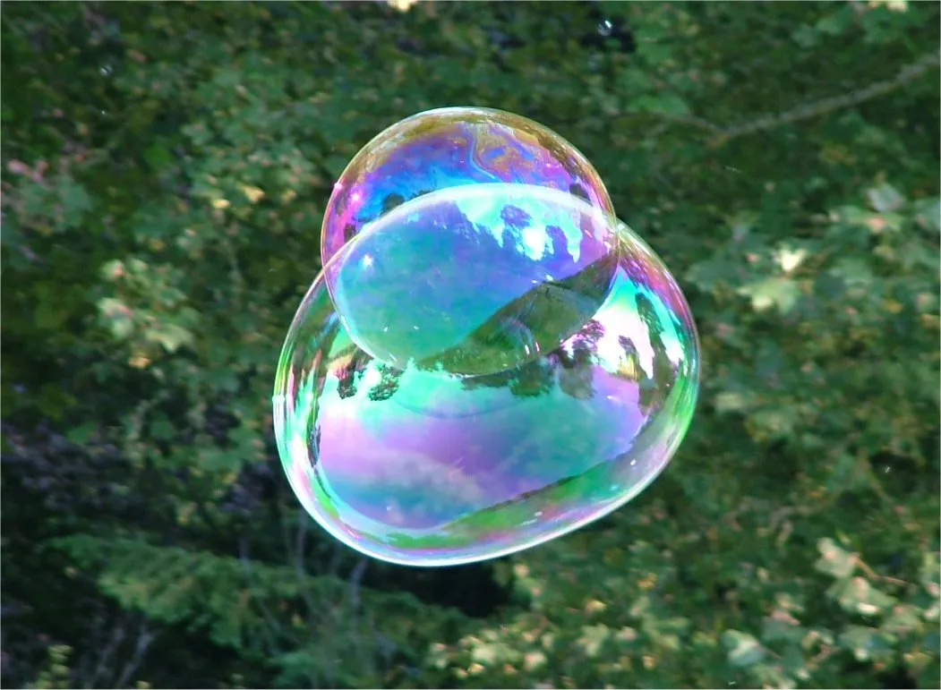 Iridescent colors shift dynamically across natural surfaces and modern automotive paint finishes