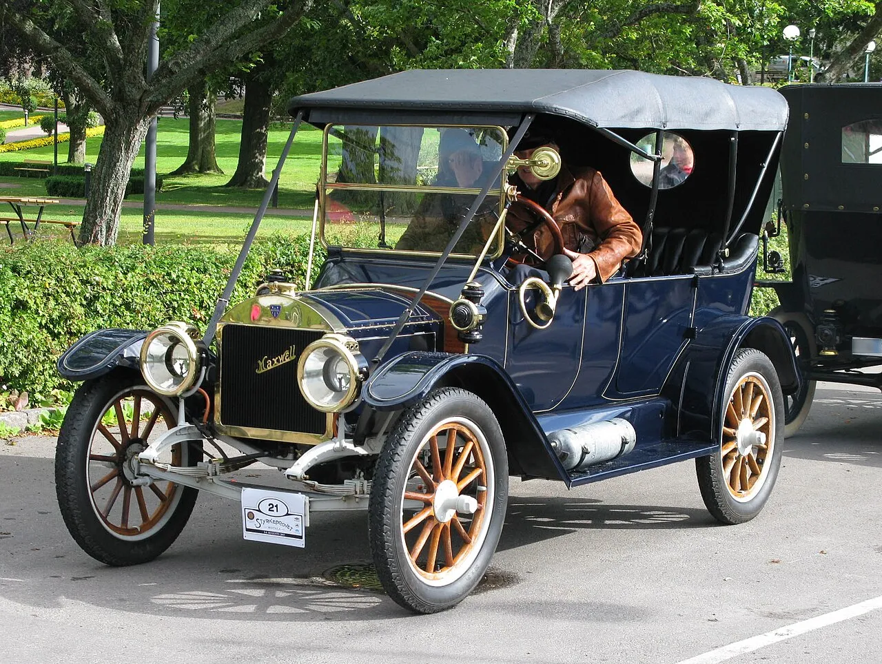 Vintage touring car parked outdoors showcasing classic open-air automotive design and heritage